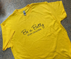 Yellow adult size Be a Betty Stay Golden in black sparkle lettering tshirt